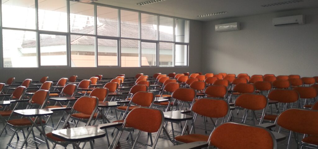 Empty classroom filled with orange chairs.