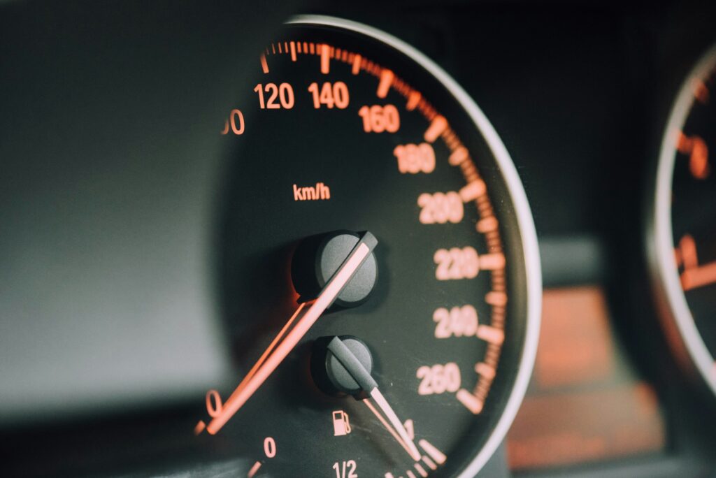 Closeup photo of a black, analogue speedometer.