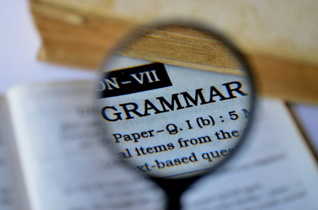 Magnifying glass focusing on the word “grammar”.