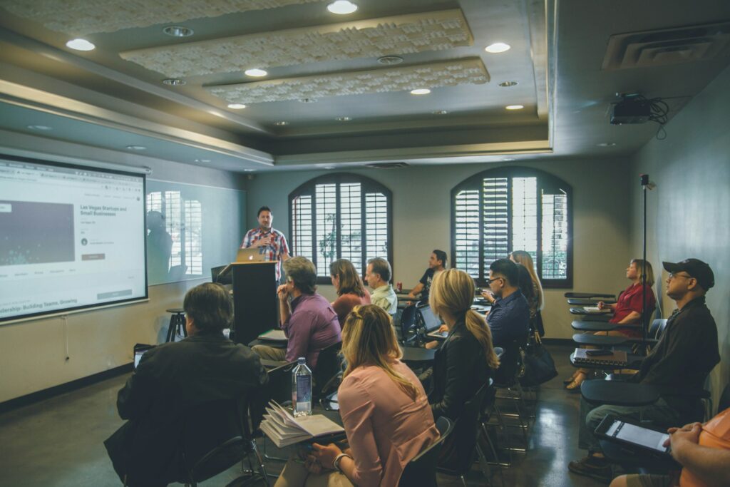 A group of people in a classroom with a projector.